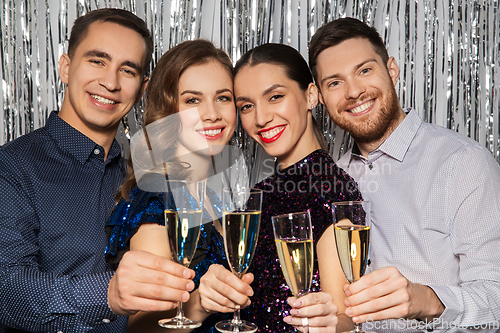 Image of happy friends toasting champagne glasses at party