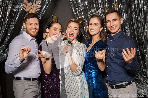 Image of friends with microphone singing at christmas party