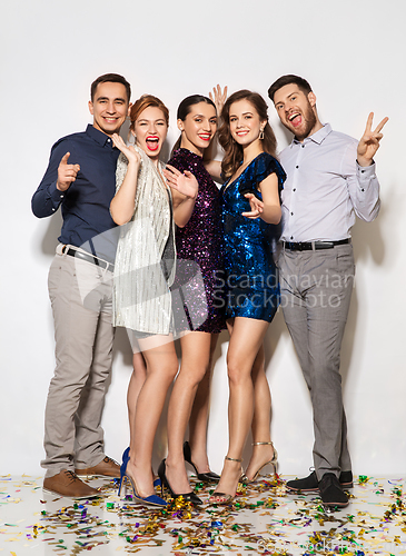 Image of happy friends at party with confetti on floor