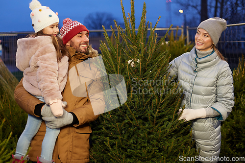 Image of happy family choosing christmas tree at market