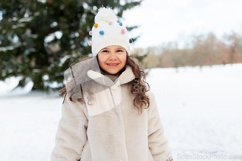 Image of happy little girl in winter clothes outdoors