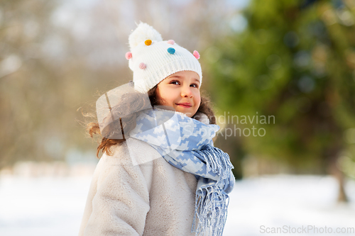 Image of happy little girl in winter clothes outdoors