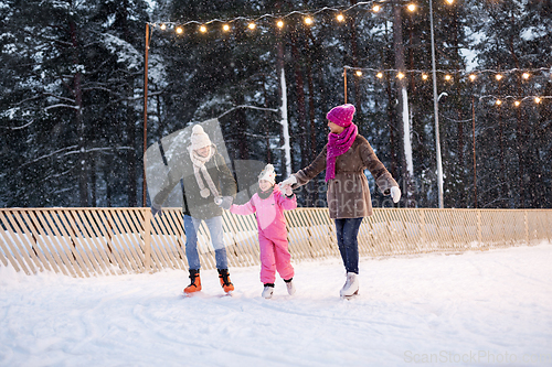 Image of happy family at outdoor skating rink in winter