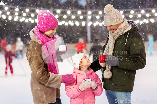 Image of happy family drinking hot tea on skating rink