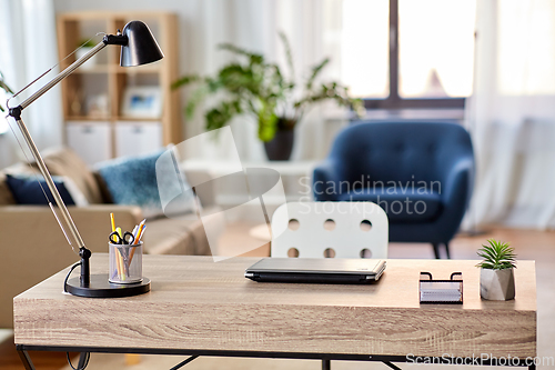 Image of laptop and lamp on table at home office