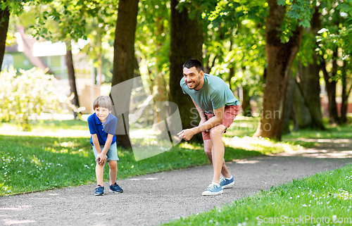 Image of happy father and son compete in running at park