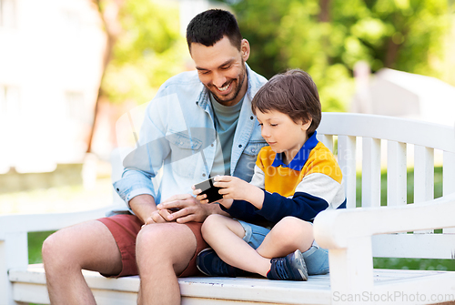 Image of father and son with smartphone at park
