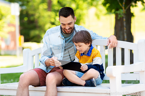 Image of father and son with tablet pc computer at park