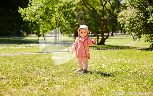 Image of happy little baby girl at park in summer