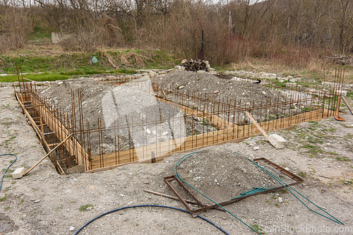 Image of The general plan for the construction of a one-story private house, a trench has been dug, formwork and reinforcement are being installed