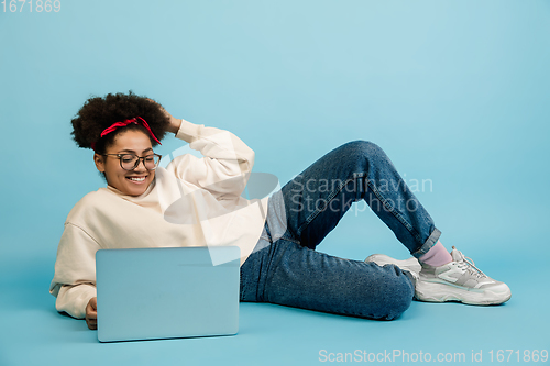 Image of African-american woman\'s portrait isolated on blue studio background with copyspace