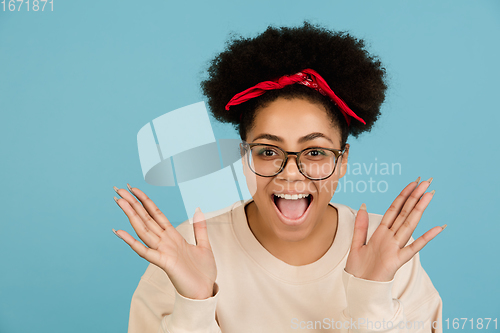 Image of African-american woman\'s portrait isolated on blue studio background with copyspace