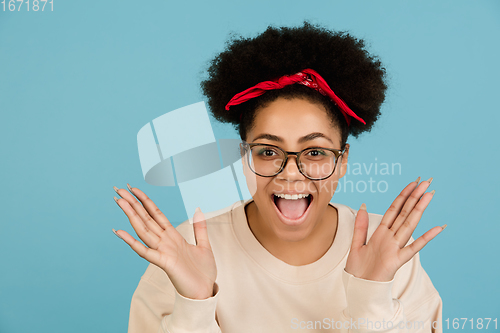 Image of African-american woman\'s portrait isolated on blue studio background with copyspace