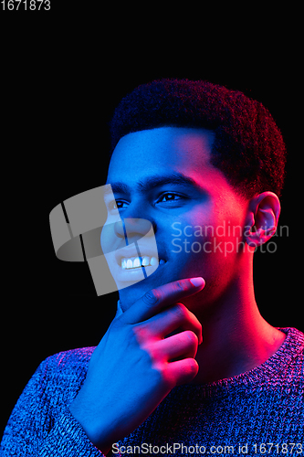 Image of African-american man\'s portrait isolated on black studio background in multicolored neon light