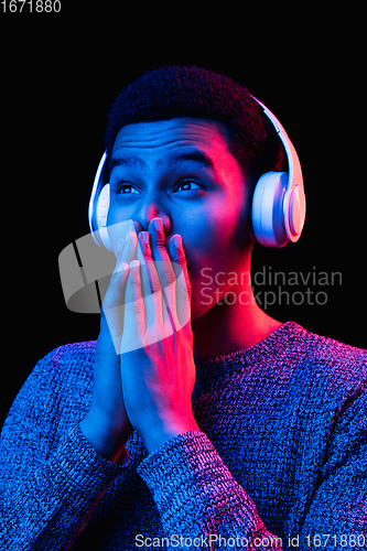 Image of African-american man\'s portrait isolated on black studio background in multicolored neon light