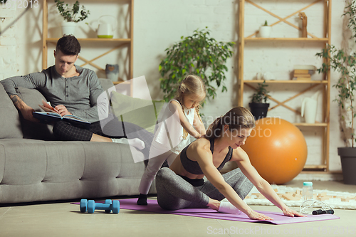 Image of Young woman exercising fitness, aerobic, yoga at home, sporty lifestyle. Getting active during lockdown, quarantine. Home gym.
