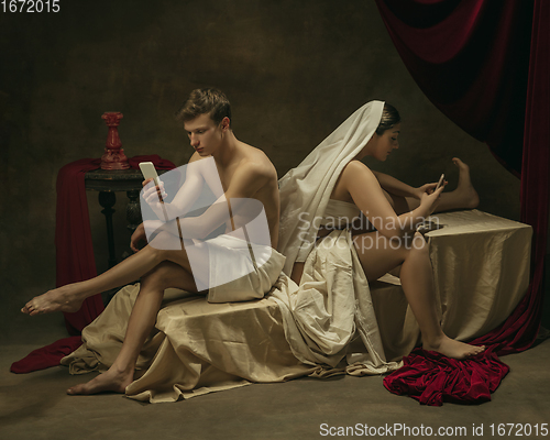 Image of Modern remake of classical artwork with modern tech theme - young medieval couple on dark background