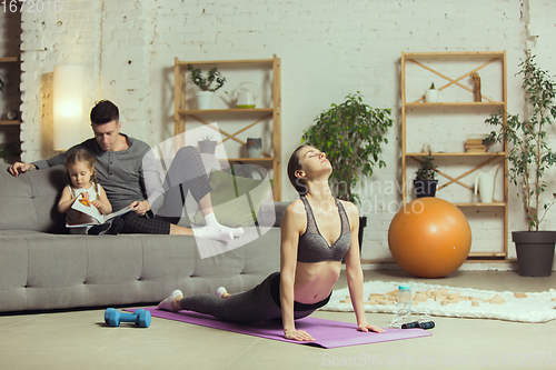 Image of Young woman exercising fitness, aerobic, yoga at home, sporty lifestyle. Getting active during lockdown, quarantine. Home gym.