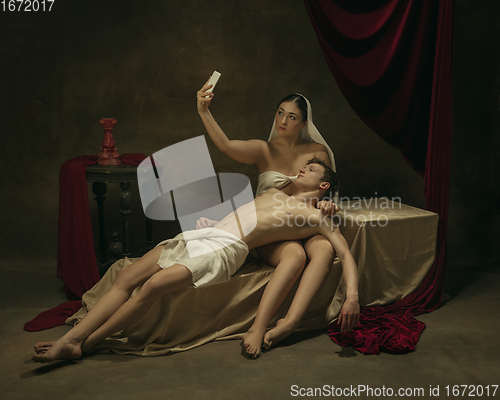 Image of Modern remake of classical artwork with modern tech theme - young medieval couple on dark background