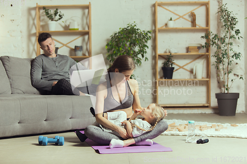 Image of Young woman exercising fitness, aerobic, yoga at home, sporty lifestyle. Getting active during lockdown, quarantine. Home gym.