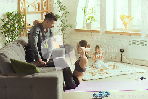 Image of Young woman exercising fitness, aerobic, yoga at home, sporty lifestyle. Getting active during lockdown, quarantine. Home gym.