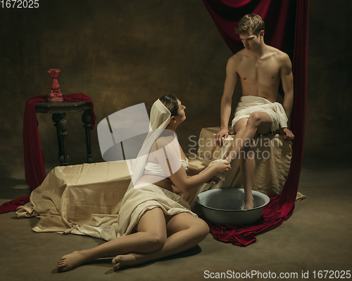 Image of Modern remake of classical artwork with coronavirus theme - young medieval couple on dark background