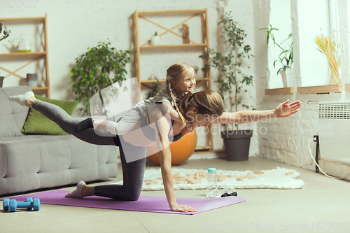 Image of Young woman exercising fitness, aerobic, yoga at home, sporty lifestyle. Getting active during lockdown, quarantine. Home gym.