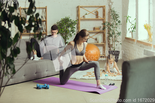Image of Young woman exercising fitness, aerobic, yoga at home, sporty lifestyle. Getting active during lockdown, quarantine. Home gym.