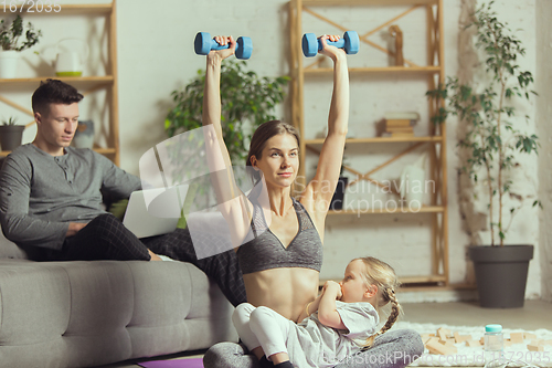 Image of Young woman exercising fitness, aerobic, yoga at home, sporty lifestyle. Getting active during lockdown, quarantine. Home gym.