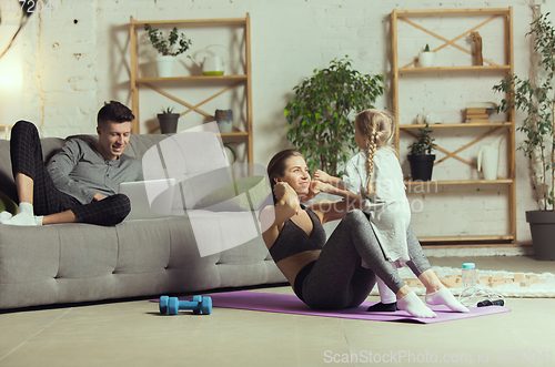 Image of Young woman exercising fitness, aerobic, yoga at home, sporty lifestyle. Getting active during lockdown, quarantine. Home gym.