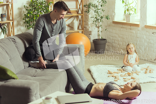 Image of Young woman exercising fitness, aerobic, yoga at home, sporty lifestyle. Getting active during lockdown, quarantine. Home gym.