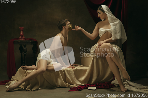 Image of Modern remake of classical artwork with coronavirus theme - young medieval couple on dark background