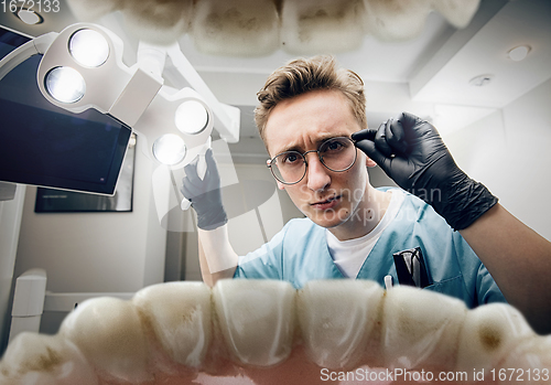 Image of Doctor looking into the mouth, checking, examining teeth