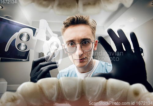 Image of Doctor looking into the mouth, checking, examining teeth