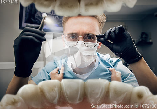 Image of Doctor looking into the mouth, checking, examining teeth