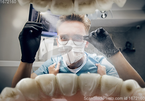 Image of Doctor looking into the mouth, checking, examining teeth