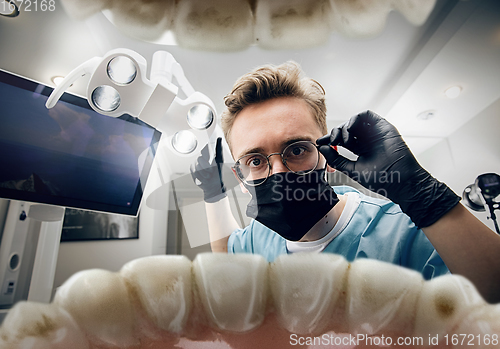 Image of Doctor looking into the mouth, checking, examining teeth