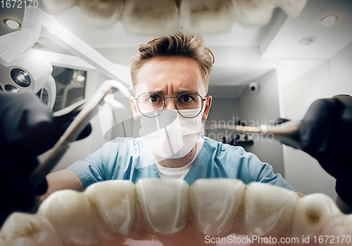 Image of Doctor looking into the mouth, checking, examining teeth
