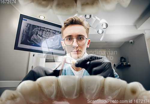 Image of Doctor looking into the mouth, checking, examining teeth