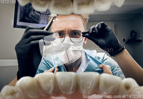 Image of Doctor looking into the mouth, checking, examining teeth