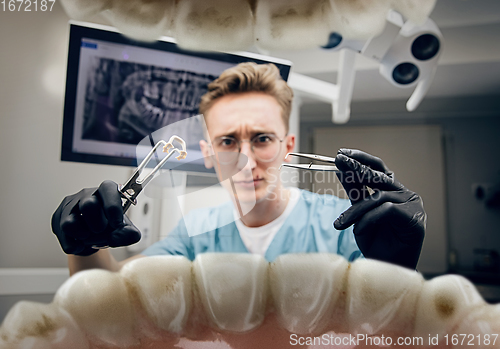 Image of Doctor looking into the mouth, checking, examining teeth