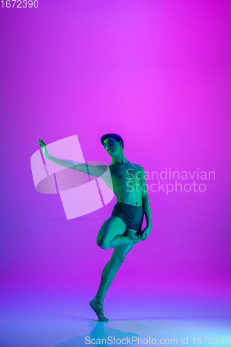 Image of Young and graceful ballet dancer isolated on purple studio background in neon light. Art, motion, action, flexibility, inspiration concept.