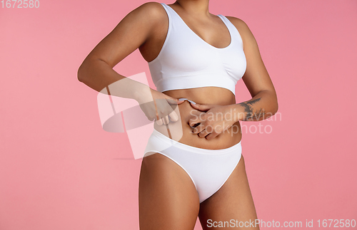 Image of Beautiful body of young african-american woman isolated on pink studio background