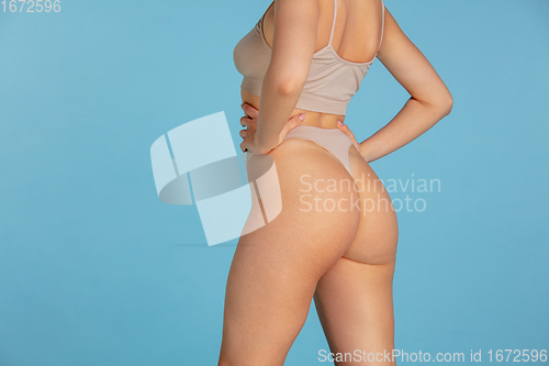 Image of Beautiful body of young caucasian woman isolated on blue studio background