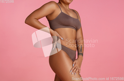 Image of Beautiful body of young african-american woman isolated on pink studio background