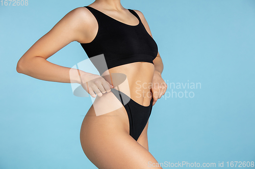 Image of Beautiful body of young caucasian woman isolated on blue studio background