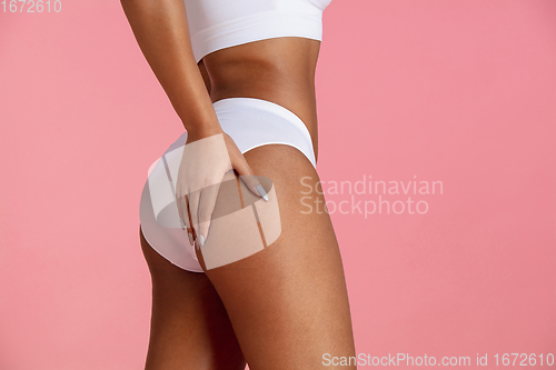 Image of Beautiful body of young african-american woman isolated on pink studio background