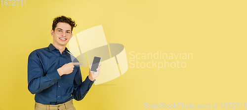 Image of Caucasian man\'s portrait isolated on yellow studio background with copyspace