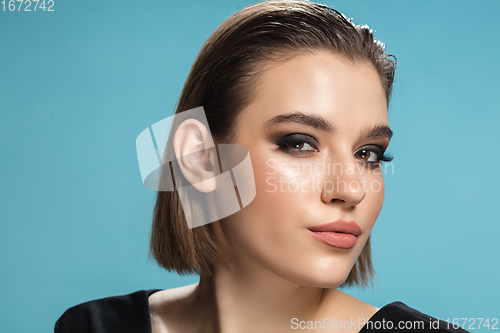 Image of Portrait of female fashion model isolated on blue studio background. Style and beauty concept. Close up.