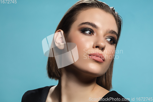 Image of Portrait of female fashion model isolated on blue studio background. Style and beauty concept. Close up.